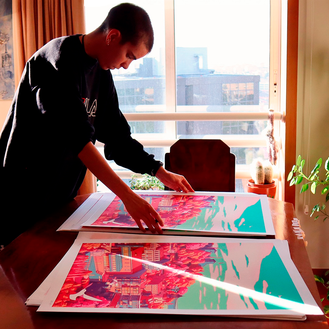camila_illustration examining colorful prints on a table, with sunlight streaming through a window and plants nearby.