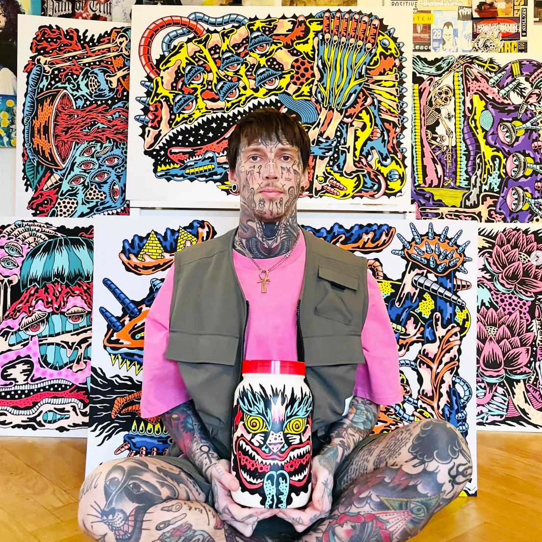 Marc UA person holding a monster-themed jar, surrounded by vibrant, abstract monster artwork on walls.