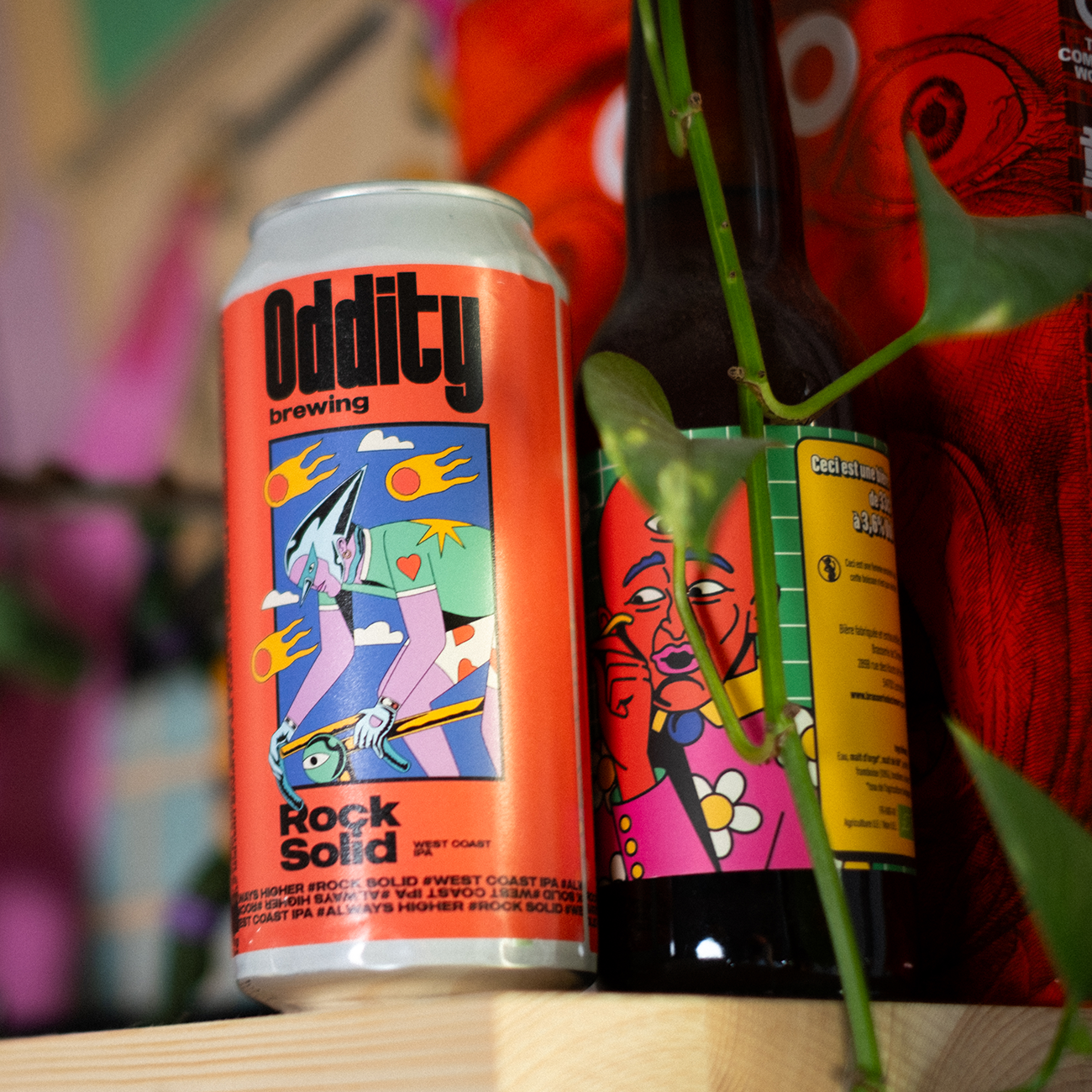 beer can with a colorful sticker label of a cyclist, with the text "ODDITY" and "ROCK SOLID", against a colorful background