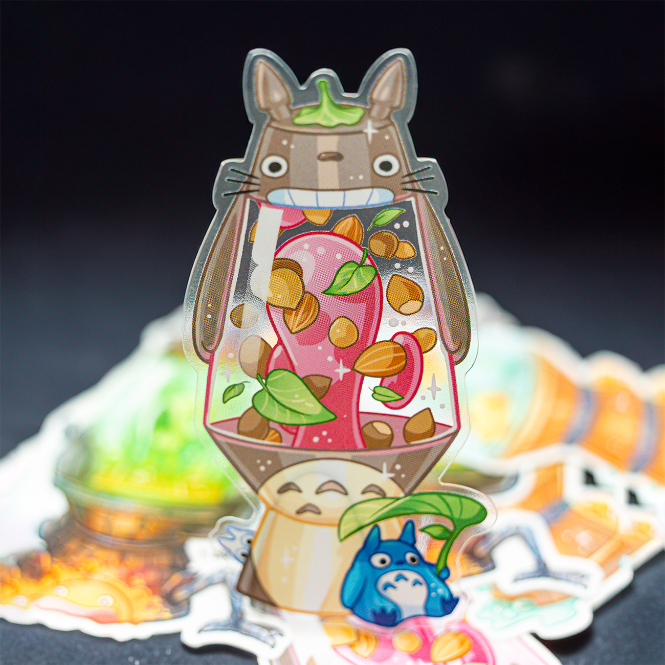 A colorful, transparent Ghilbi-inspired sticker featuring a cartoon creature holding a cup filled with vibrant mushrooms and leaves, in a lava lamp..