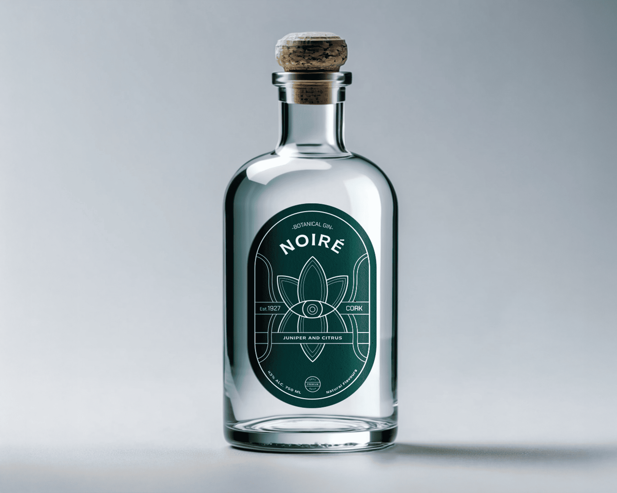 Clear glass bottle with a cork stopper, featuring a green label that reads "Noire" with a floral design and text "Juniper and Citrus."