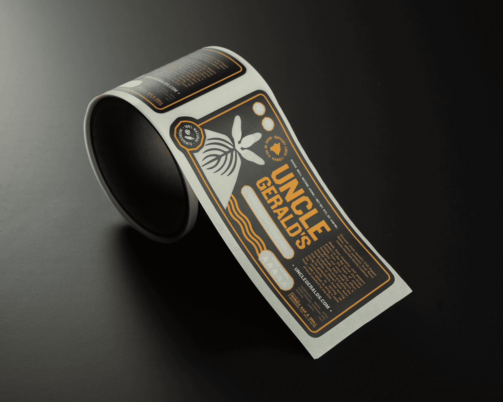 A roll of custom-designed labels with "Uncle Gerald's" in bold text, featuring a bee and honeycomb motif, on a dark background.
