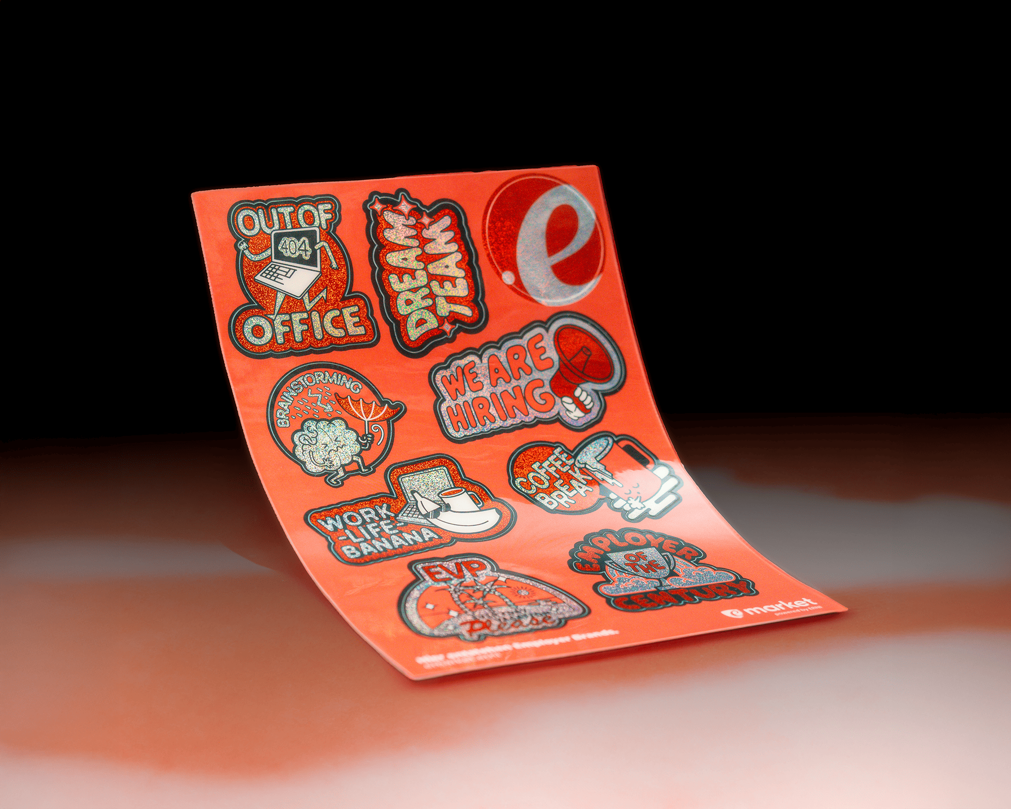 A sheet of colorful stickers on a red background, featuring phrases like "Out of Office," "We Are Hiring," and "Employee of the Month."