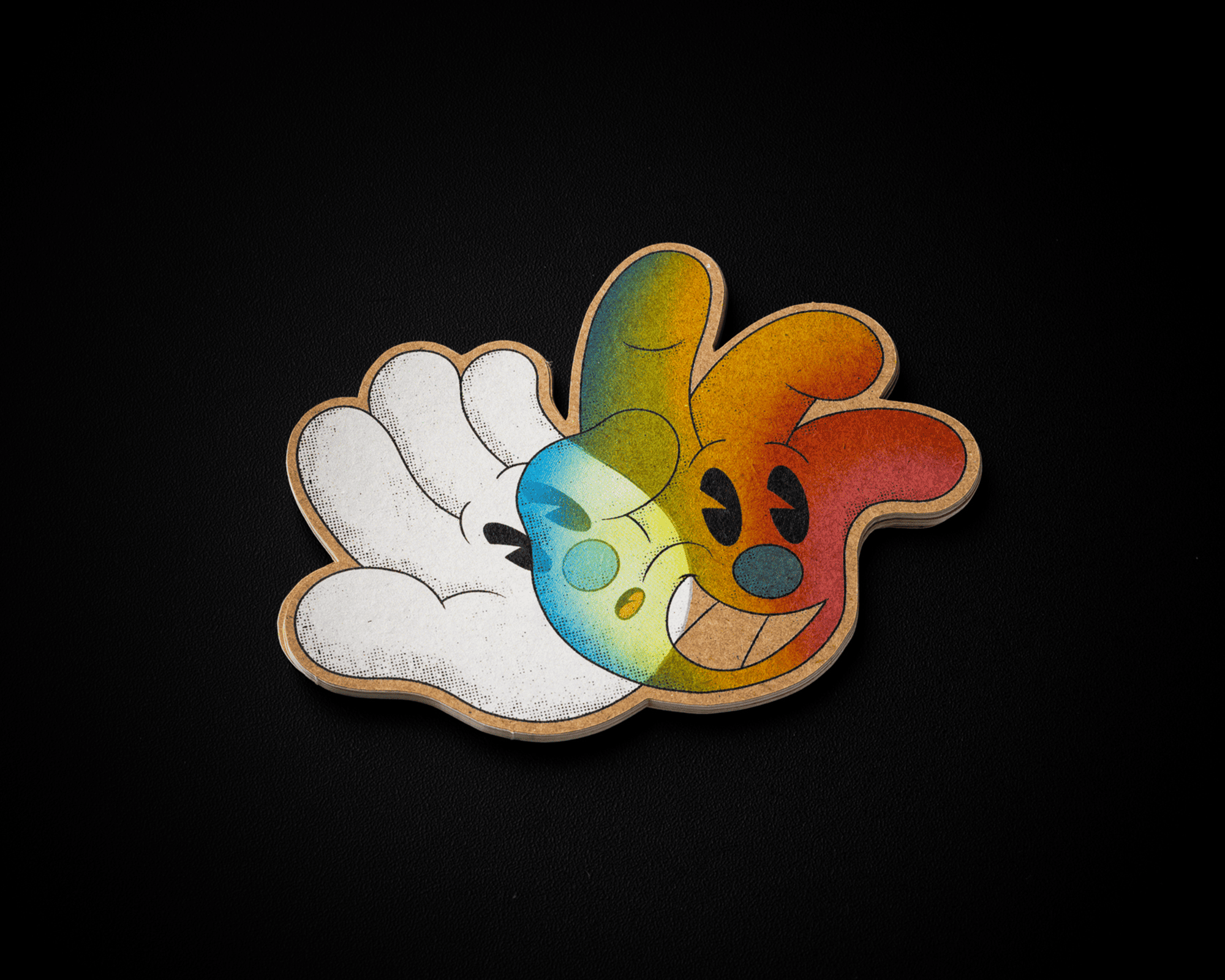 A colorful kraft sticker, cartoon-style hand with a smiling face, blending vibrant hues, set against a dark background.