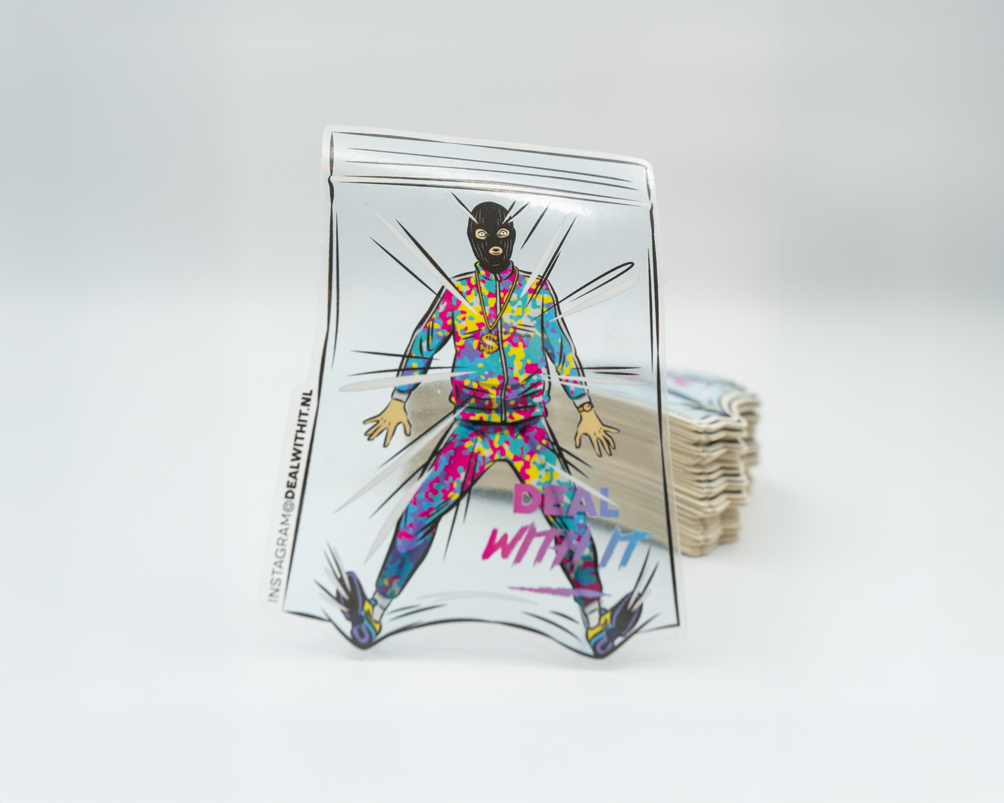 Transparent die cut sticker of a masked person in a colorful suit inside a transparent, bag-shaped object, with "DEAL WITH IT" text.