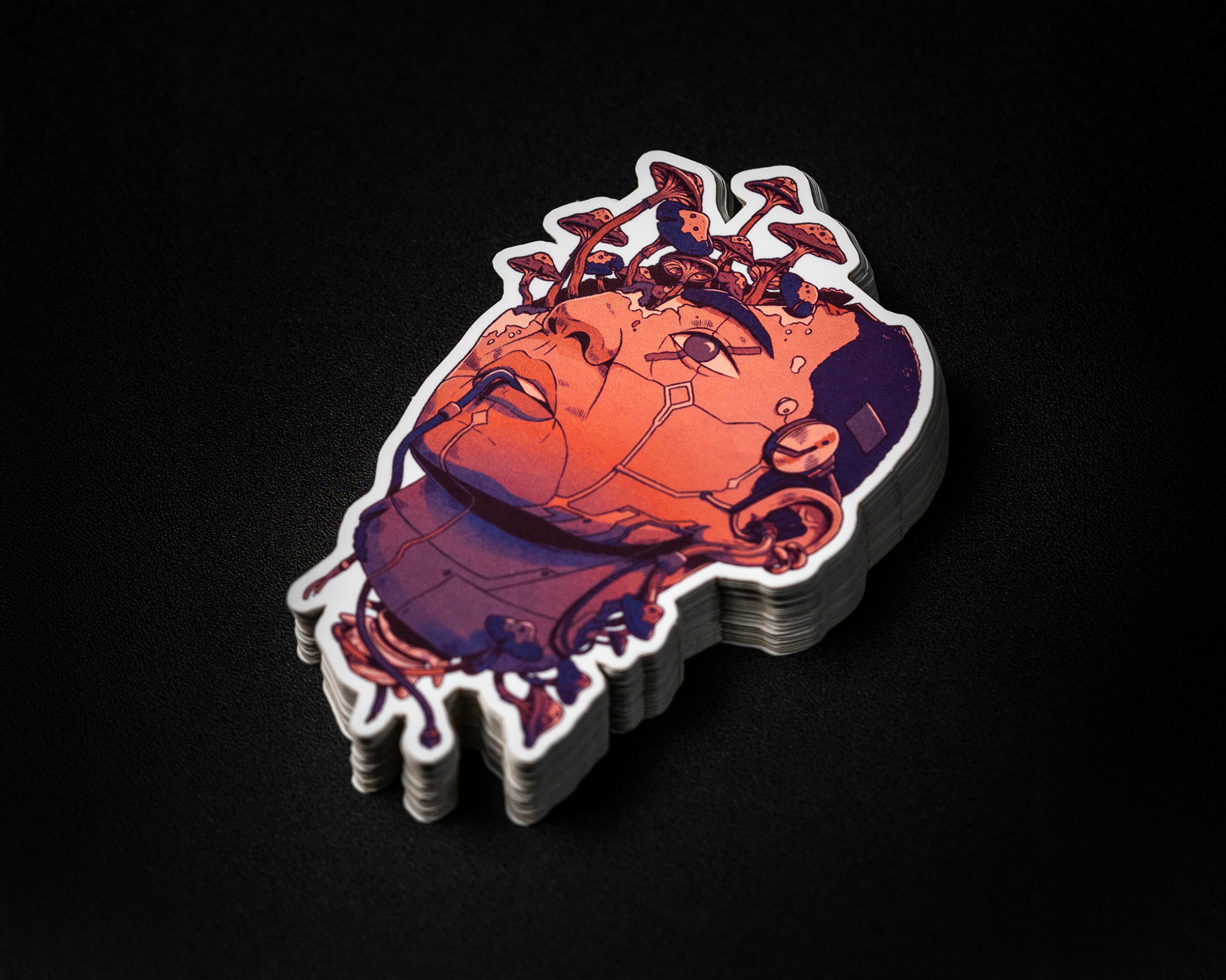 Stack of die cut stickers featuring a stylized, futuristic illustration of a human head with mechanical elements on a dark background.