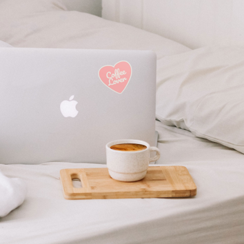 A laptop computer with die cut stickers sitting on top of a bed