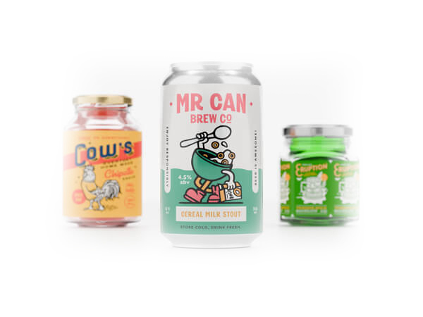 Three cans of beverage with custom labels on roll on them.
