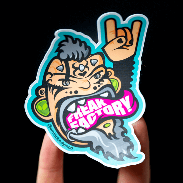 A hand holding a die cut sticker of a cartoon character.