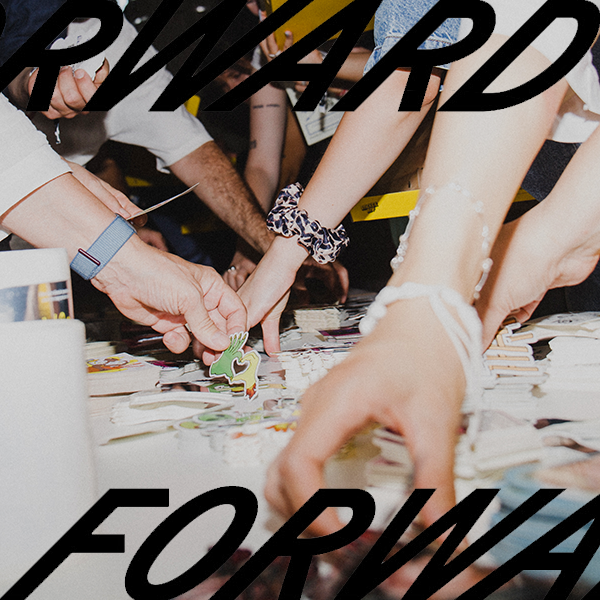 People reaching across a table, picking up various colorful stickers.