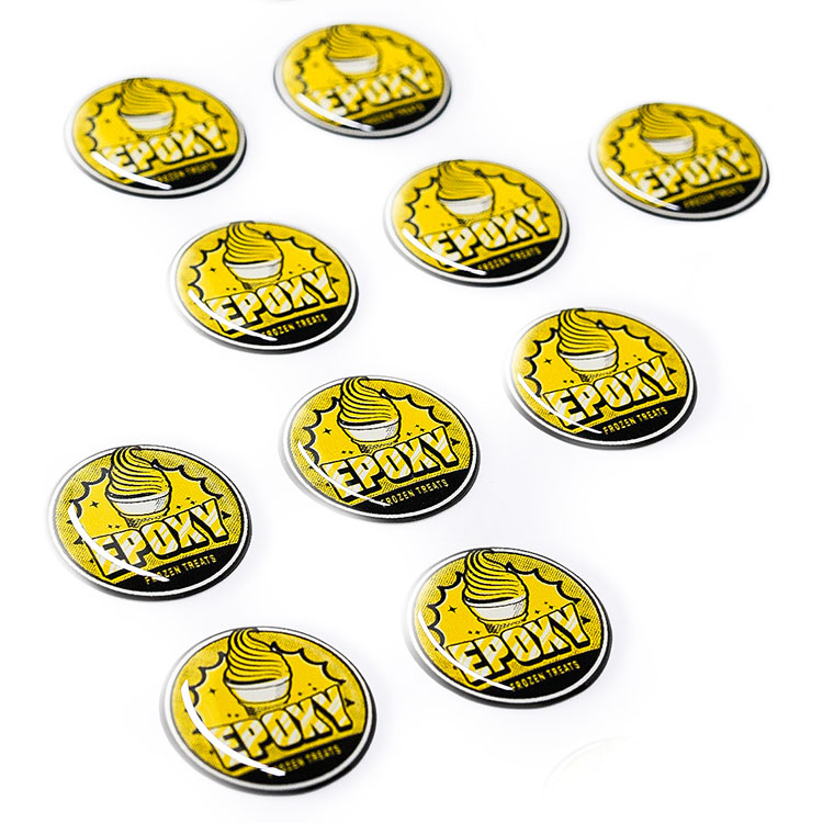 A bunch of yellow and black Epoxy stickers on a white surface.